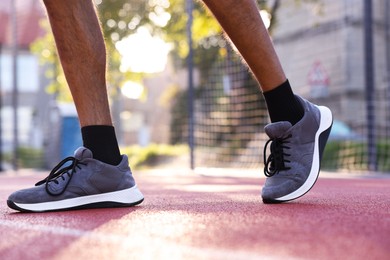 Photo of Man in sneakers running at stadium, closeup