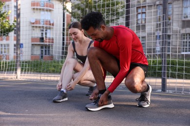 Photo of Runners tying shoelaces of their sneakers at stadium