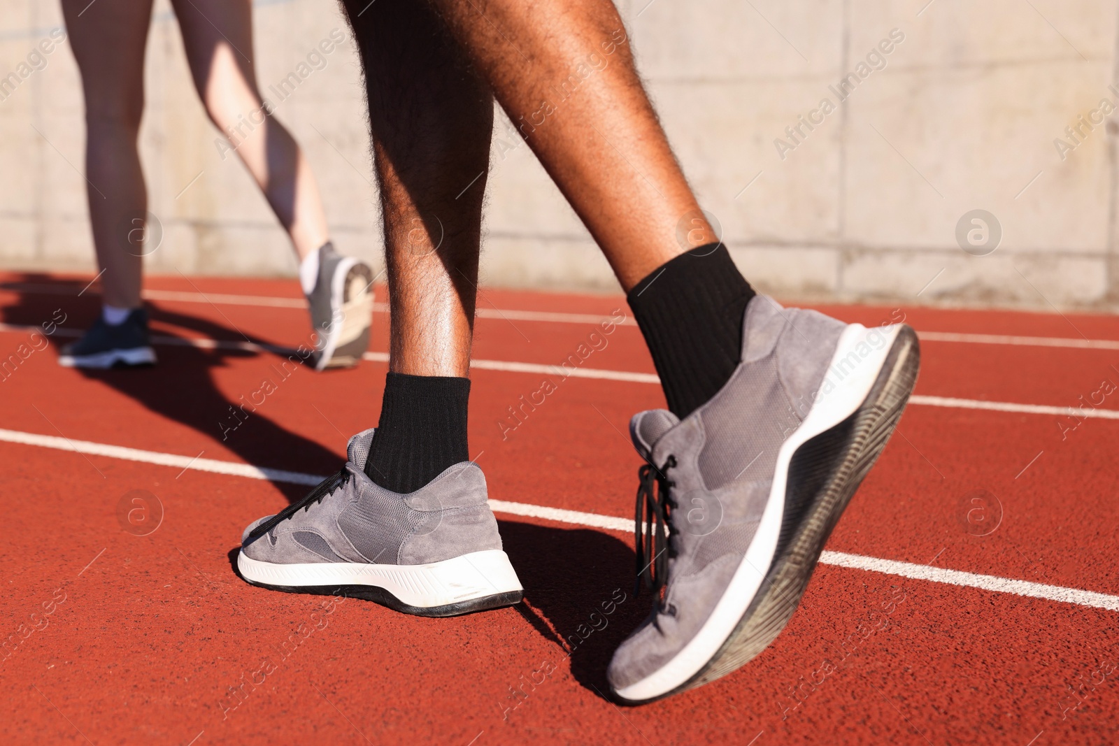 Runners walking at stadium, closeup. Healthy lifestyle Photo of Runners walking at stadium, closeup. Healthy lifestyle