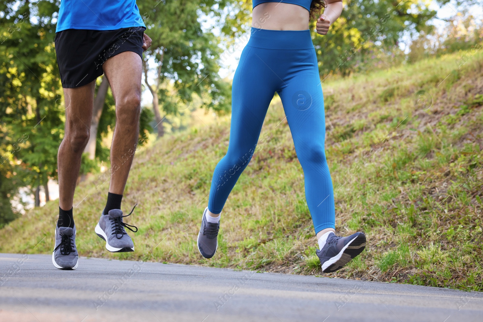 Couple in sportswear running in park, closeup Photo of Couple in sportswear running in park, closeup