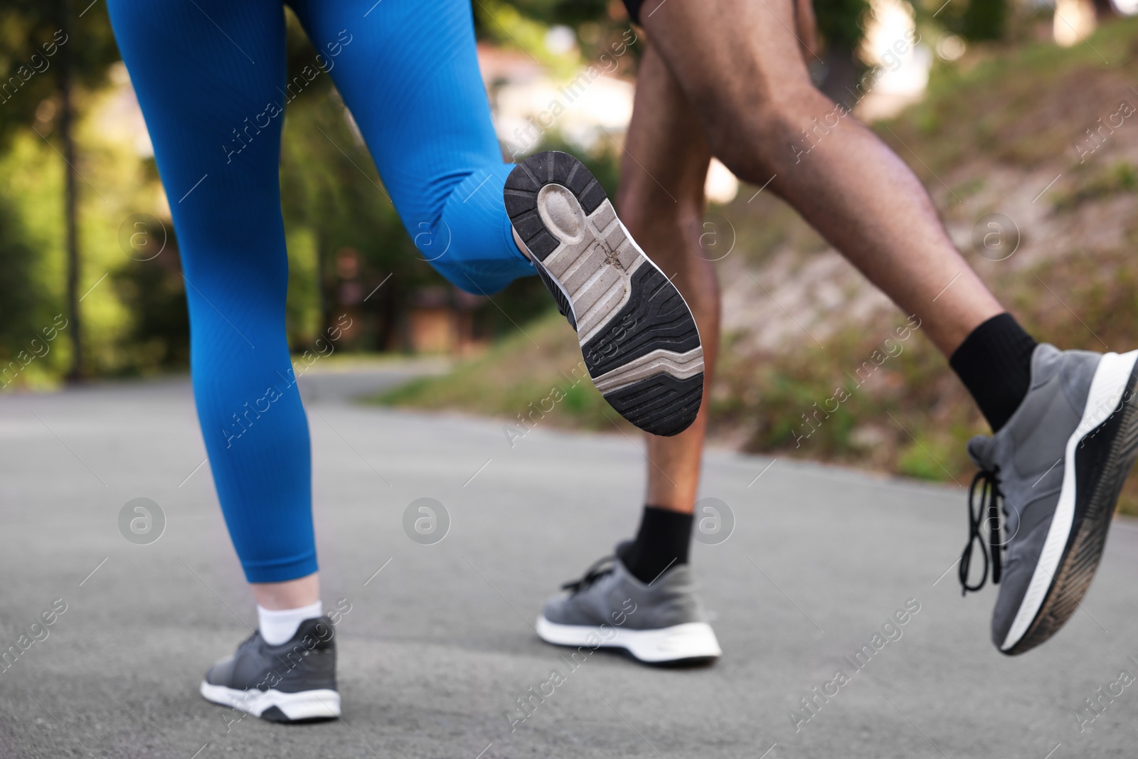 Couple in sneakers running in park, closeup Photo of Couple in sneakers running in park, closeup