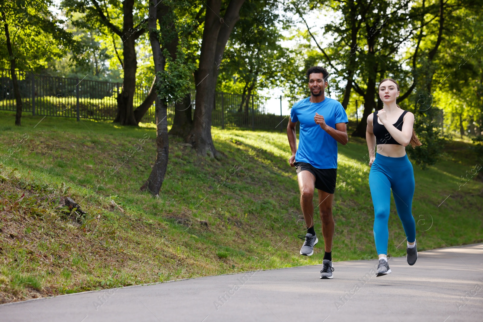 Couple in sportswear running in park. Space for text Photo of Couple in sportswear running in park. Space for text