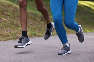 Photo of Couple in sneakers running in park, closeup