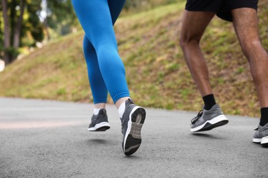Photo of Couple in sneakers running in park, closeup