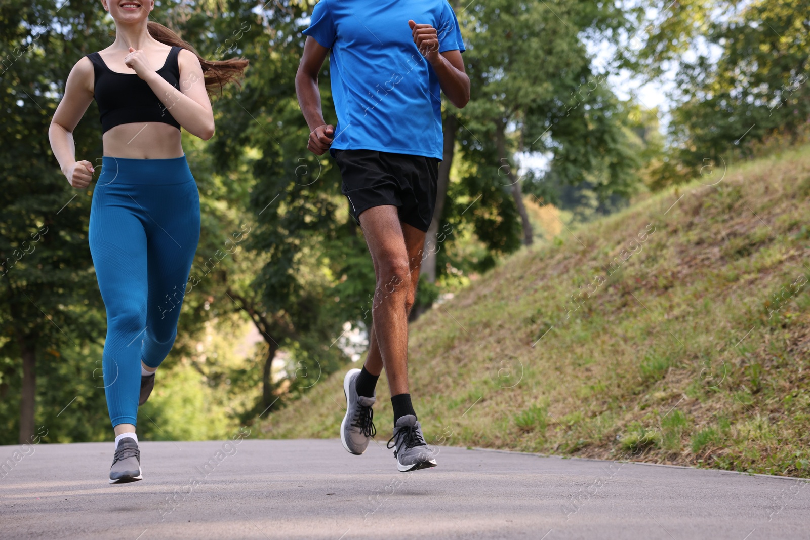Couple in sportswear running in park, closeup. Space for text Photo of Couple in sportswear running in park, closeup. Space for text