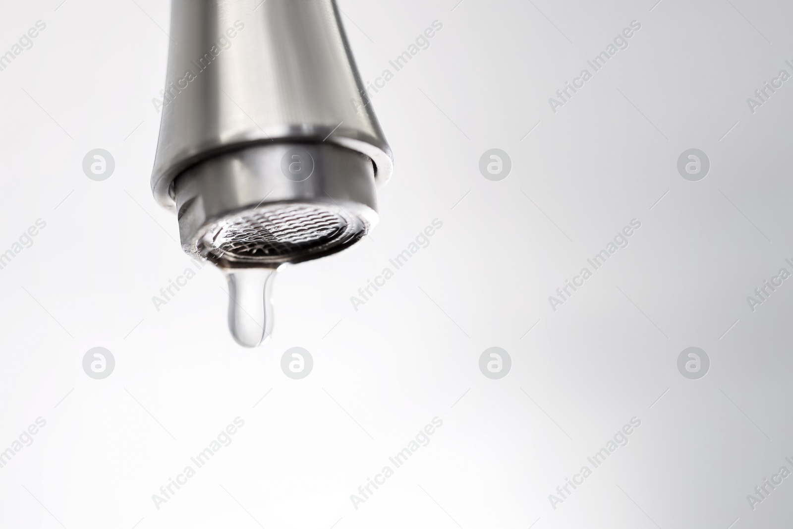 Photo of Save water concept. Water dripping from tap on light background, closeup. Space for text