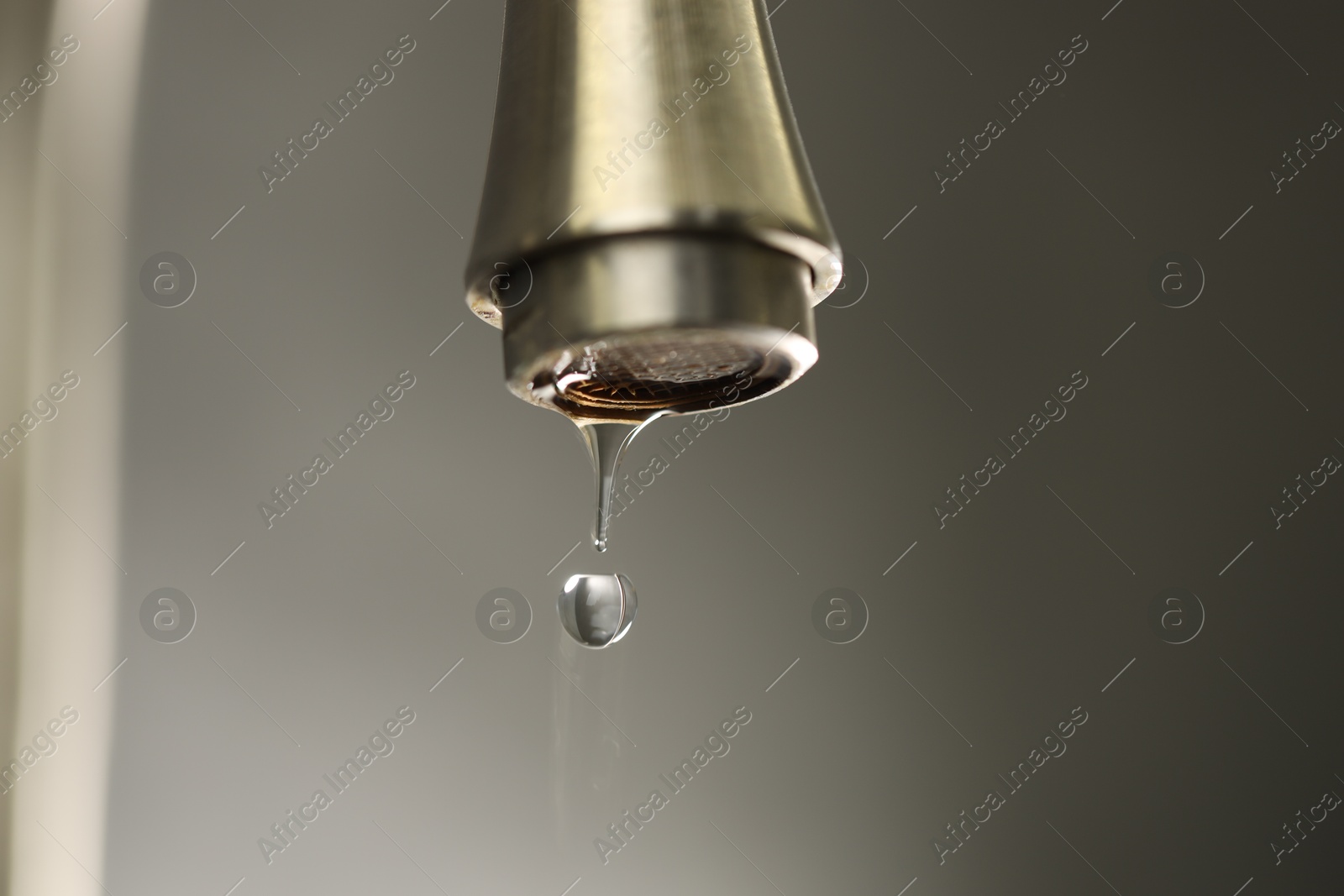 Photo of Save water concept. Water dripping from tap on grey background, closeup