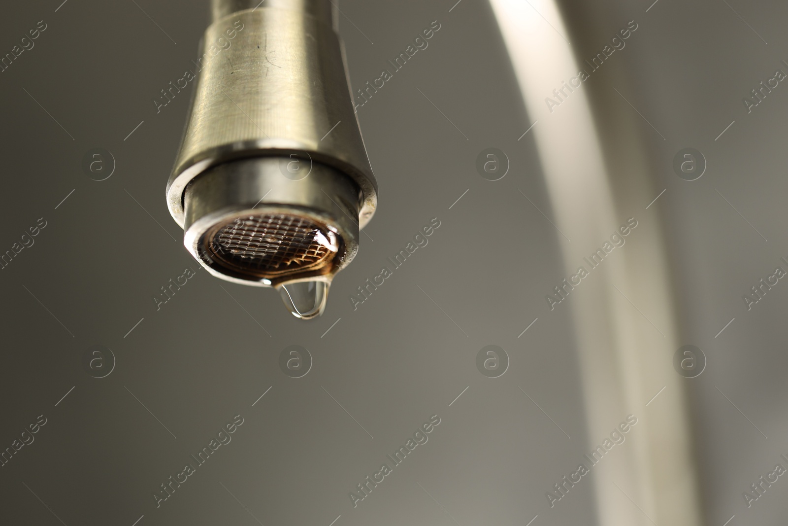 Photo of Save water concept. Water dripping from tap on grey background, closeup. Space for text