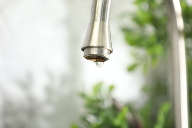 Photo of Save water concept. Water dripping from tap indoors, closeup. Space for text