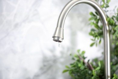 Photo of Save water concept. Water dripping from tap indoors, closeup. Space for text