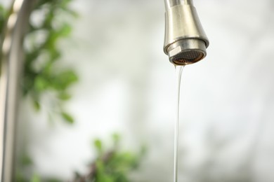 Photo of Save water concept. Water dripping from tap indoors, closeup. Space for text