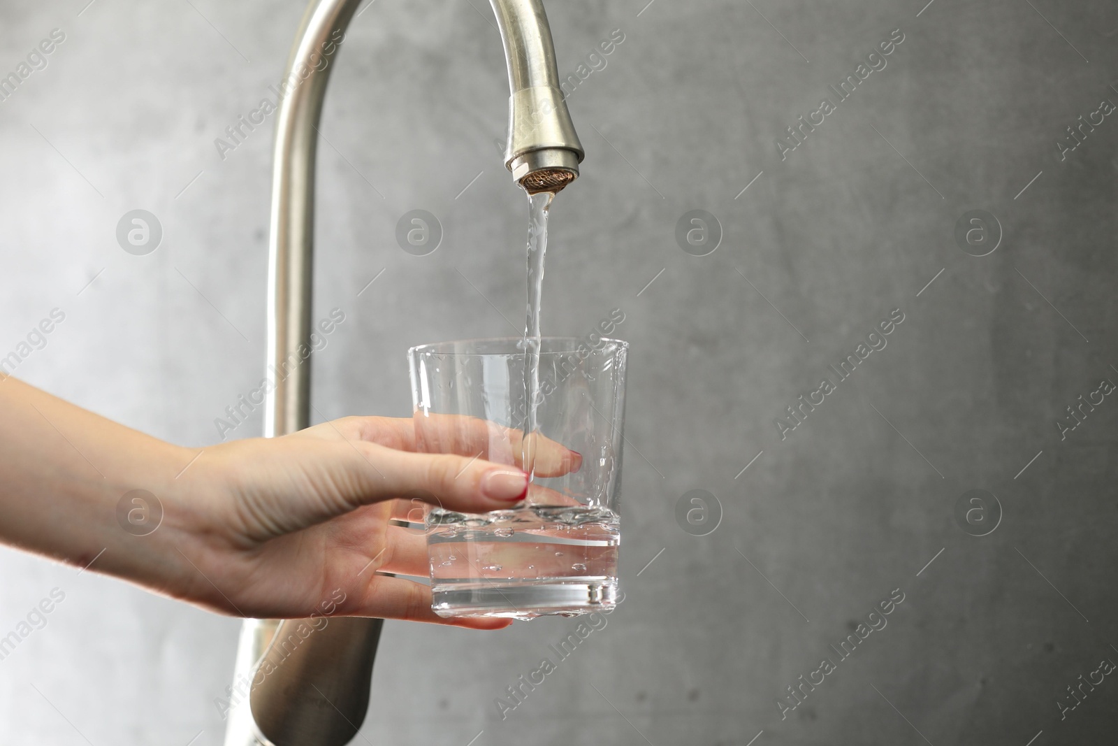 Photo of Water saving concept. Woman filling glass with tap water indoors, closeup. Space for text