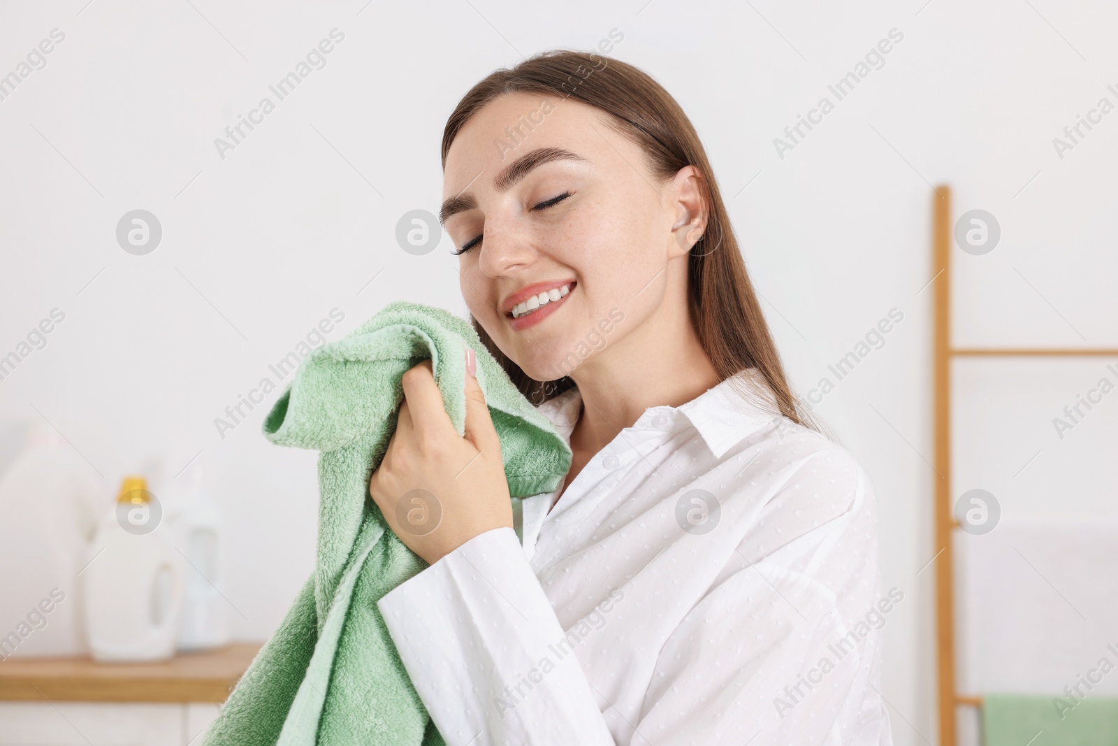 Photo of Happy woman with clean laundry at home