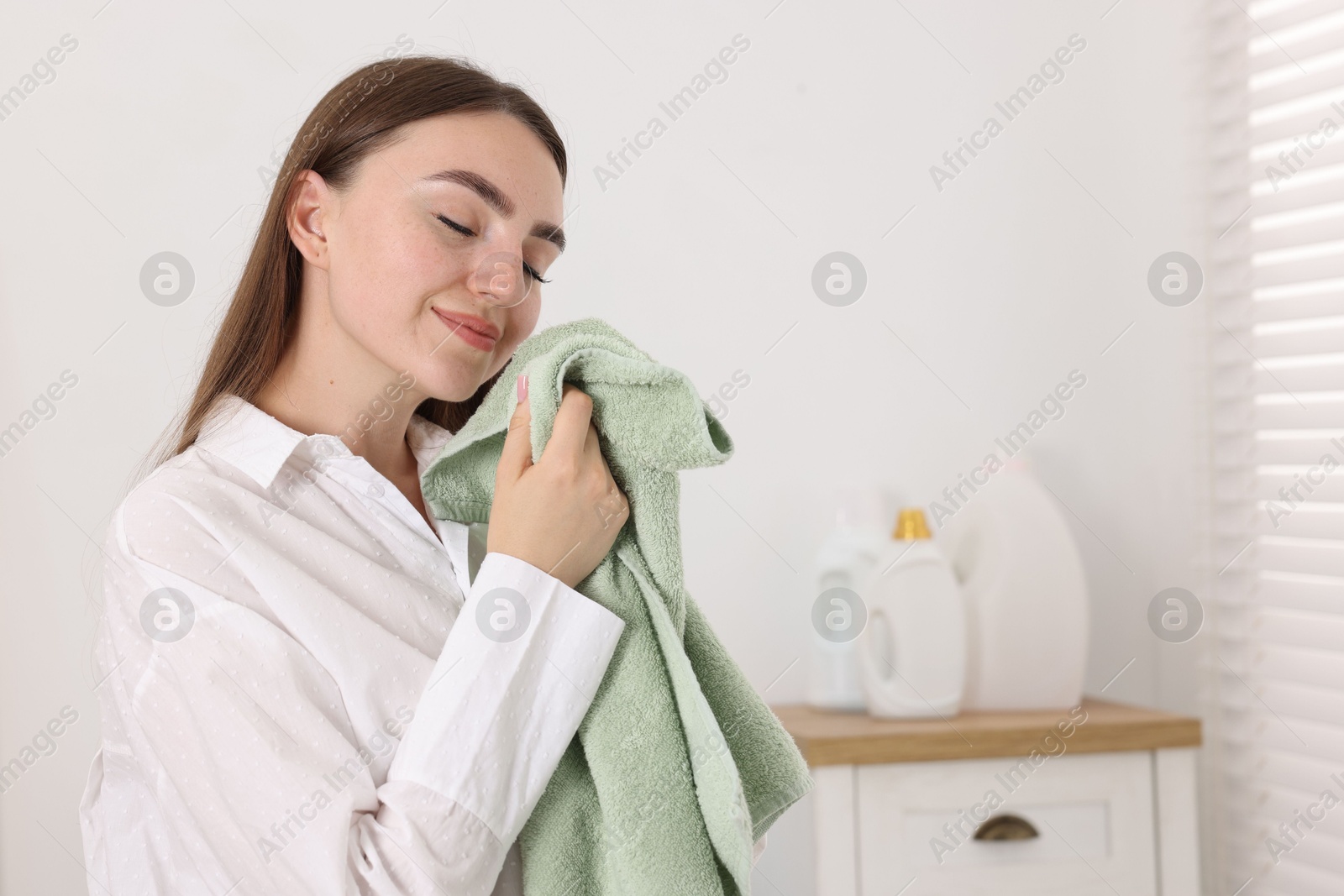 Photo of Woman with clean laundry indoors, space for text