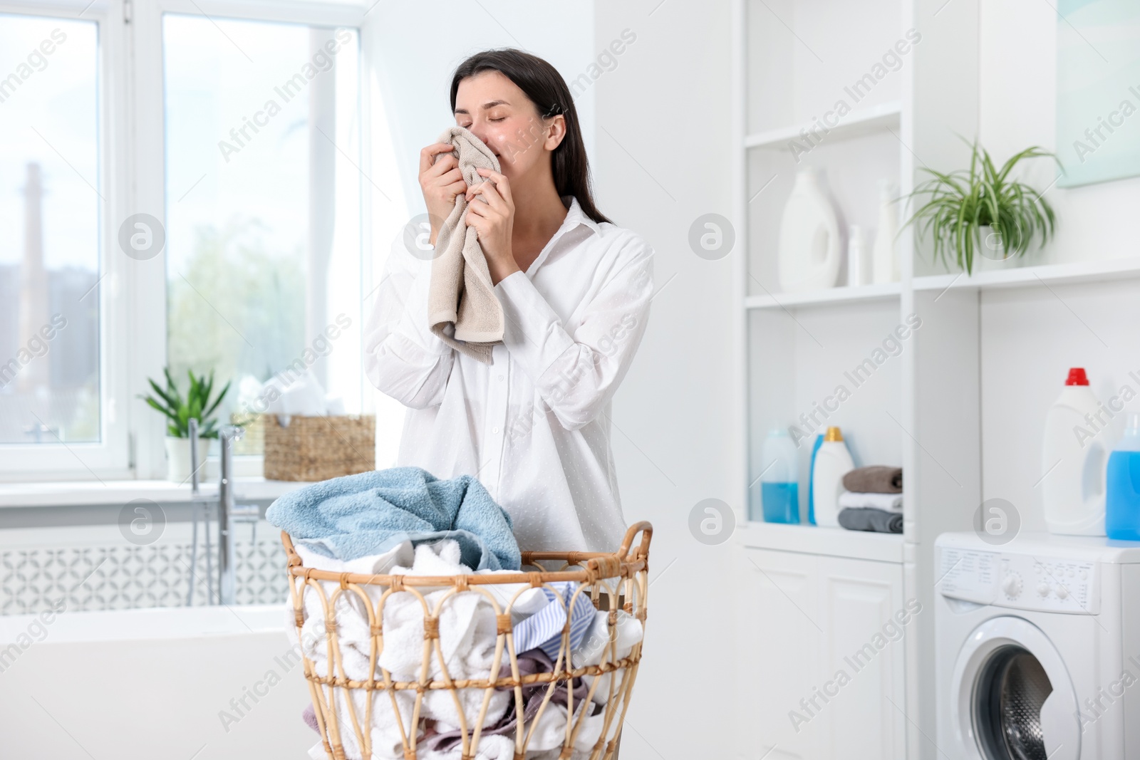 Photo of Woman with clean laundry indoors, space for text