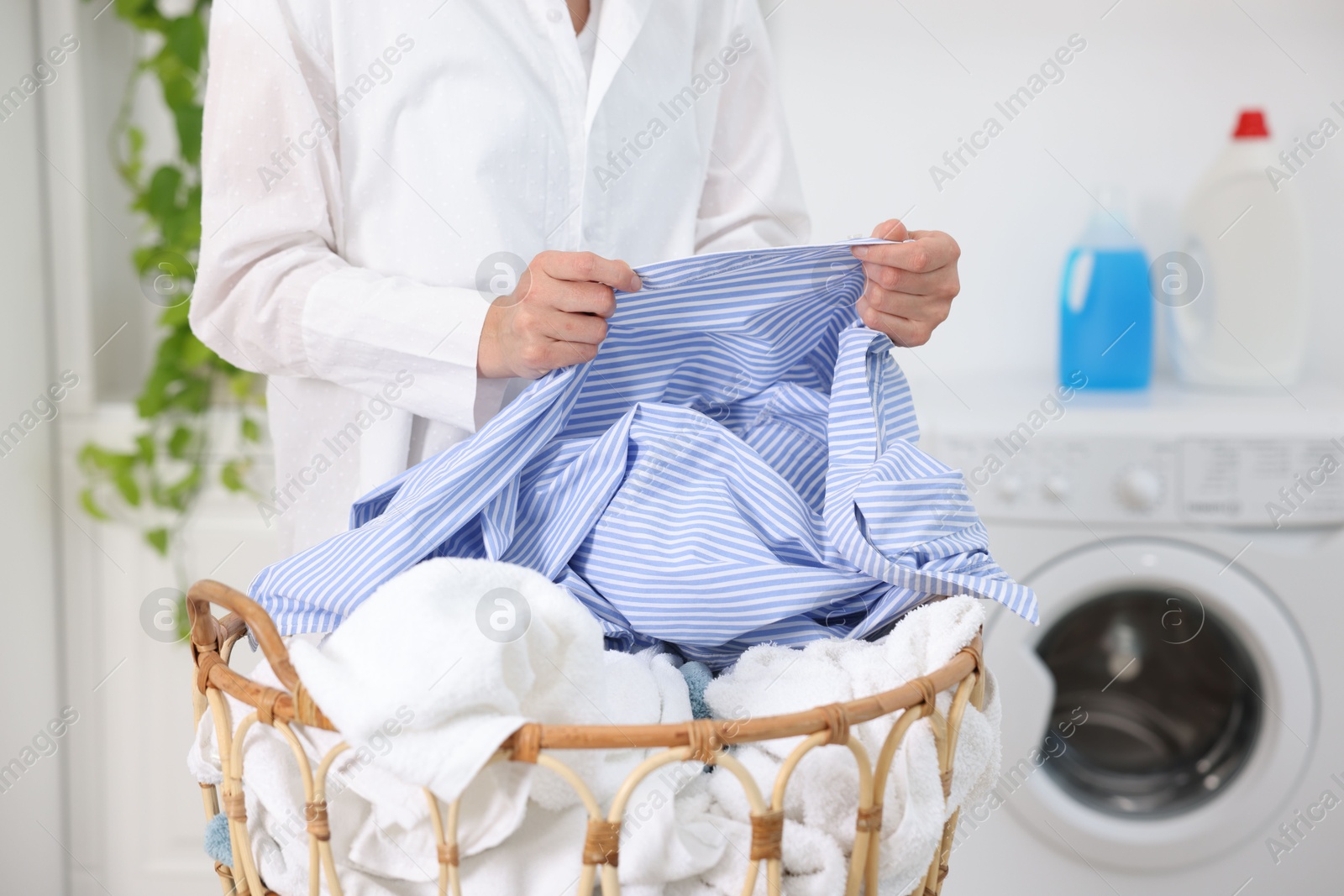 Woman with laundry near washing machine indoors, closeup Photo of Woman with laundry near washing machine indoors, closeup