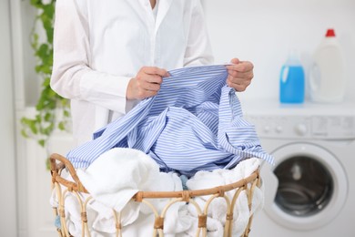 Photo of Woman with laundry near washing machine indoors, closeup
