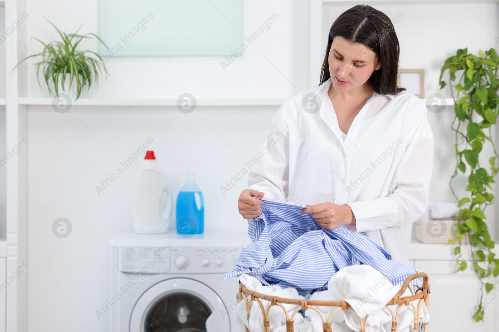 Photo of Woman with laundry near washing machine indoors, space for text