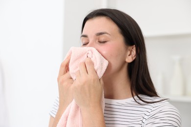 Photo of Young woman with clean laundry at home