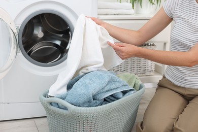 Photo of Woman with laundry near washing machine indoors, closeup