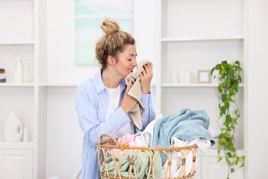 Photo of Woman with basket full of laundry indoors