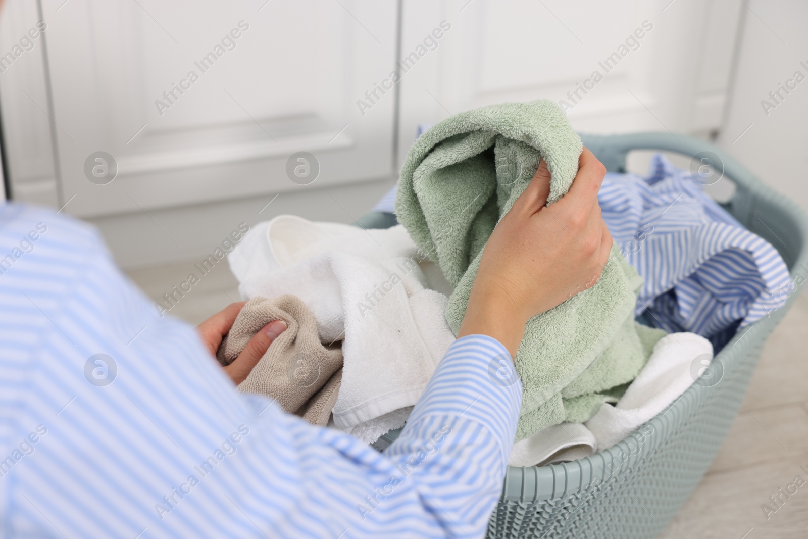 Photo of Woman with basket full of laundry indoors, closeup