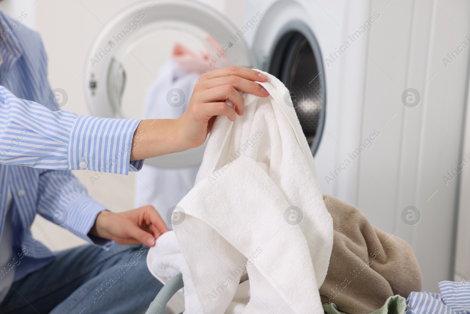 Photo of Woman with laundry near washing machine indoors, closeup