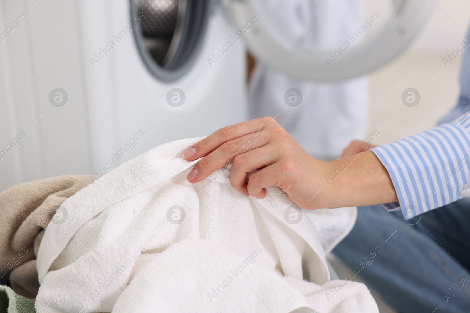 Photo of Woman with laundry near washing machine indoors, closeup