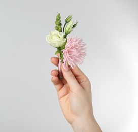 Photo of Woman with stylish small boutonniere on light grey background, closeup