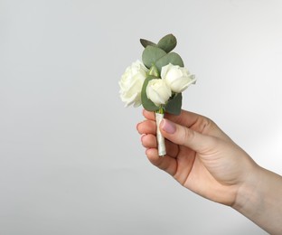 Photo of Woman with stylish small boutonniere on light grey background, closeup. Space for text