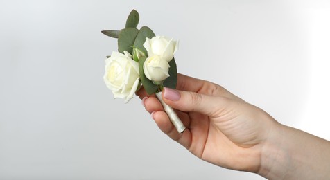 Photo of Woman with stylish small boutonniere on light grey background, closeup. Space for text