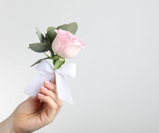 Photo of Woman with stylish small boutonniere on light grey background, closeup. Space for text