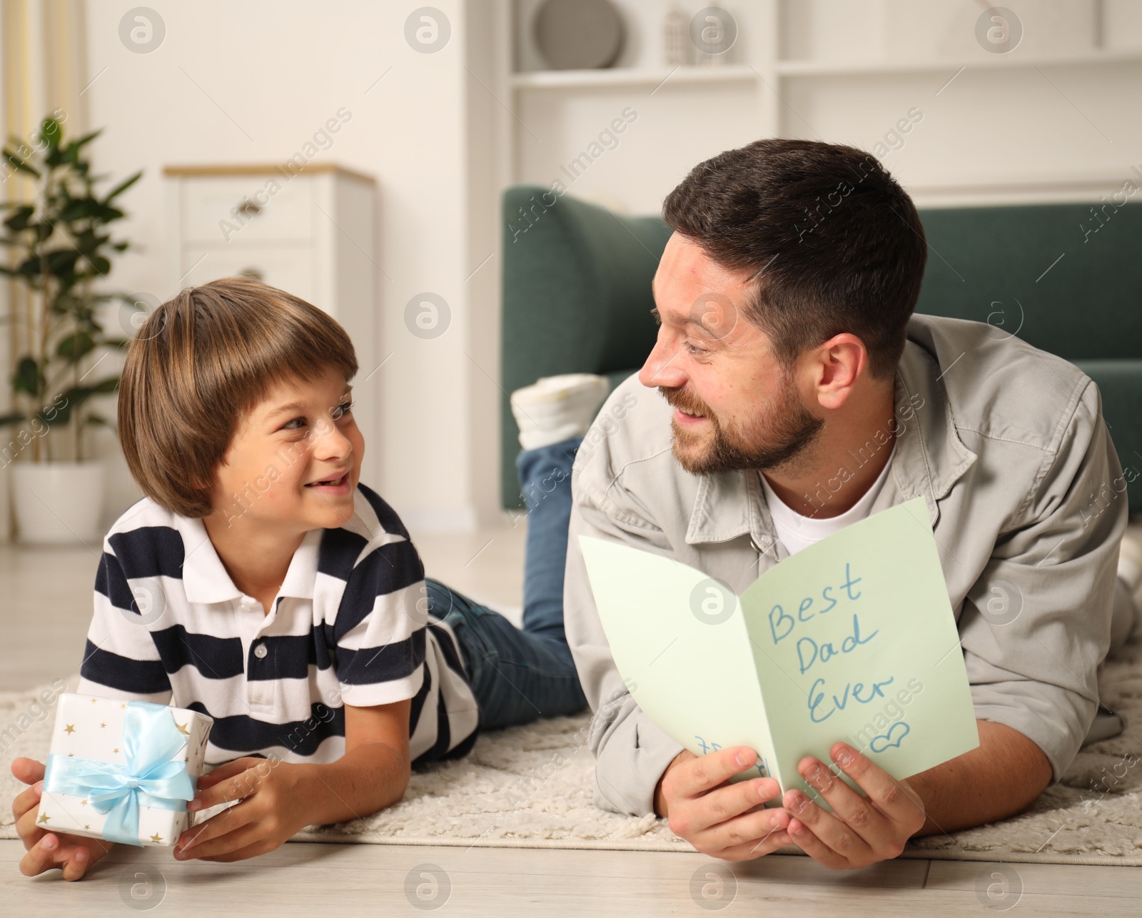 Happy Father's Day. Son giving his dad gift and card at home Photo of Happy Father's Day. Son giving his dad gift and card at home