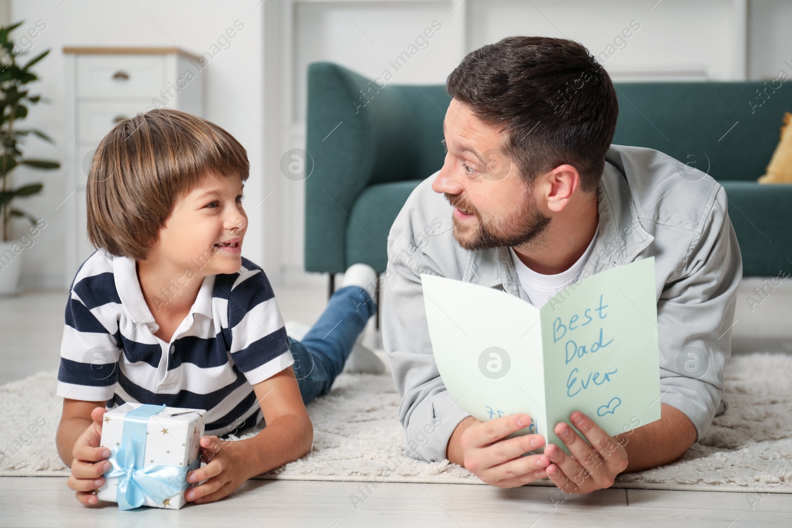 Happy Father's Day. Son giving his dad gift and card at home Photo of Happy Father's Day. Son giving his dad gift and card at home
