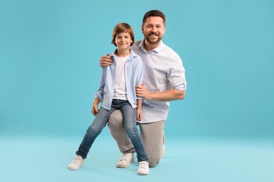 Photo of Father and son on light blue background