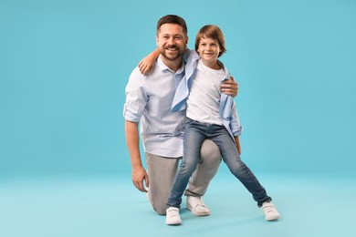 Photo of Father and son on light blue background