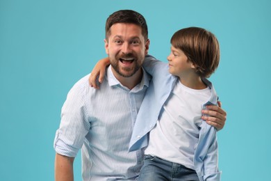 Photo of Father and son on light blue background