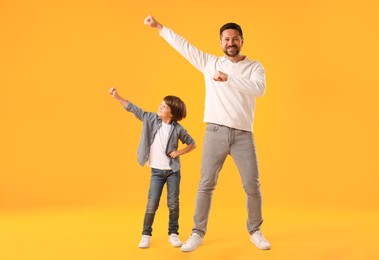 Photo of Father and son having fun on yellow background