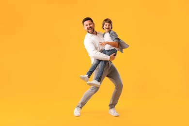Photo of Father and son having fun on yellow background