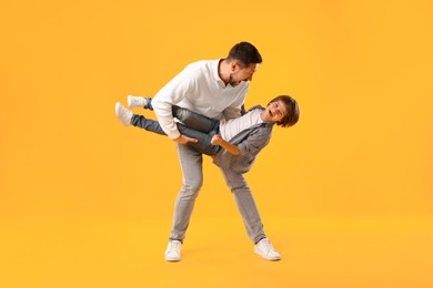 Photo of Father and son having fun on yellow background