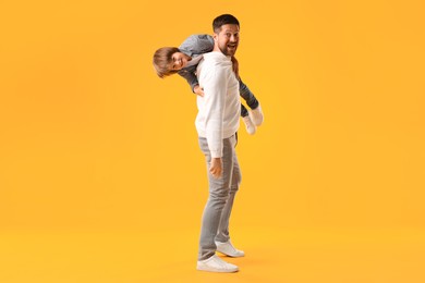 Photo of Father and son having fun on yellow background
