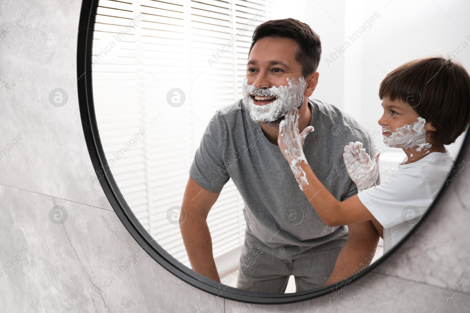 Father and son with shaving foam on their faces in bathroom Photo of Father and son with shaving foam on their faces in bathroom