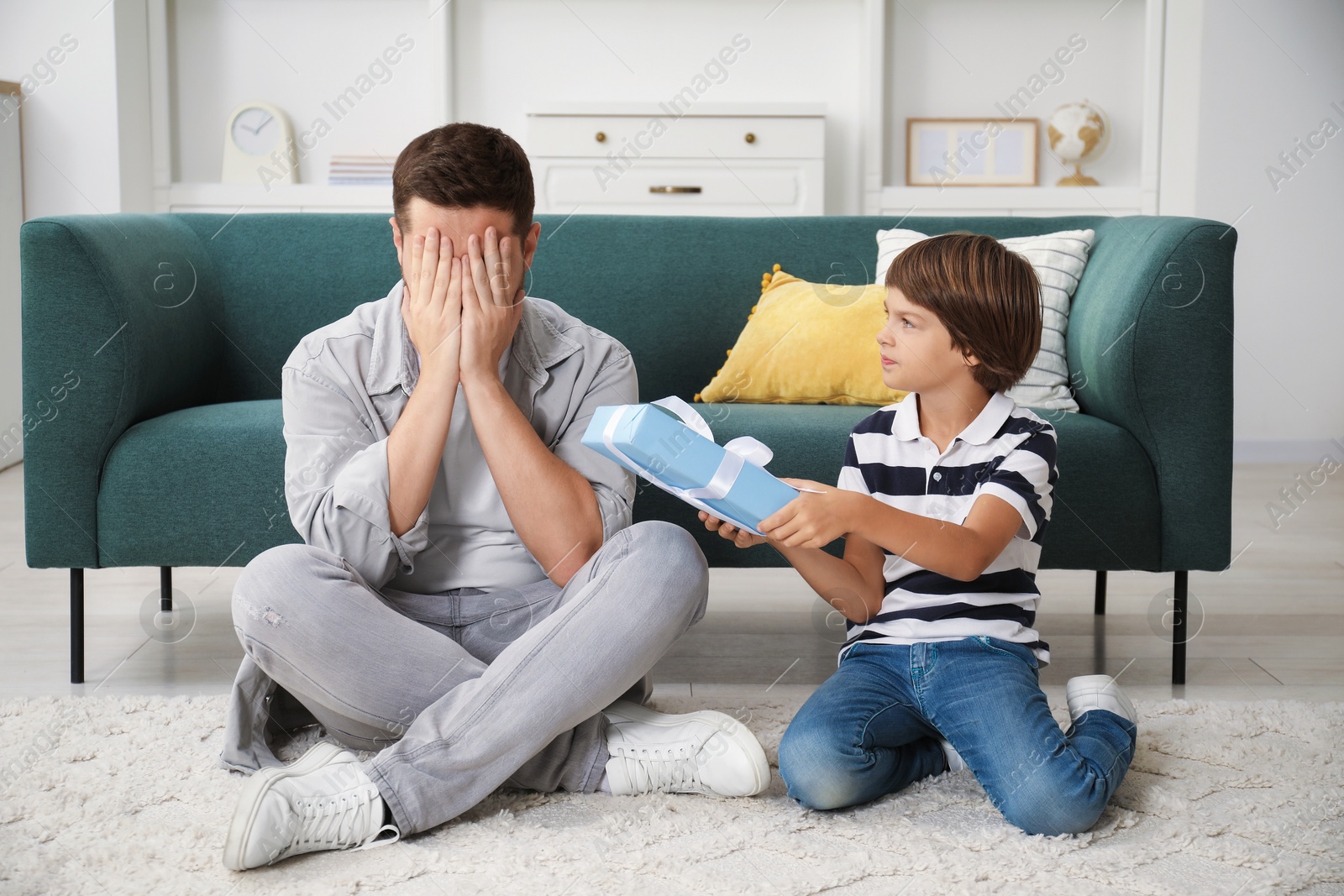 Photo of Happy Father's Day. Son giving his dad gift at home