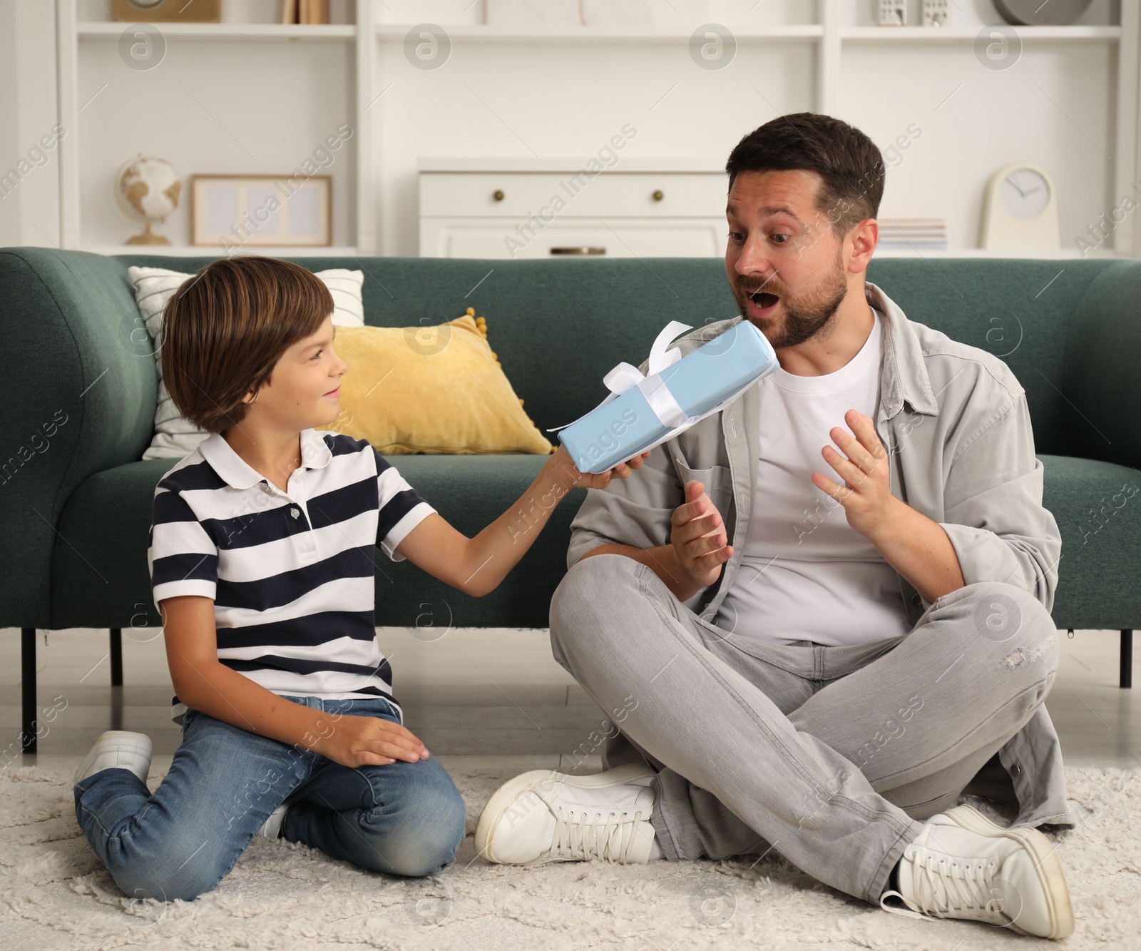Photo of Happy Father's Day. Son giving his dad gift at home