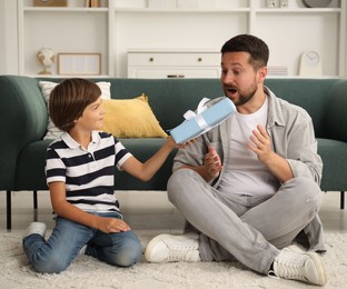 Photo of Happy Father's Day. Son giving his dad gift at home
