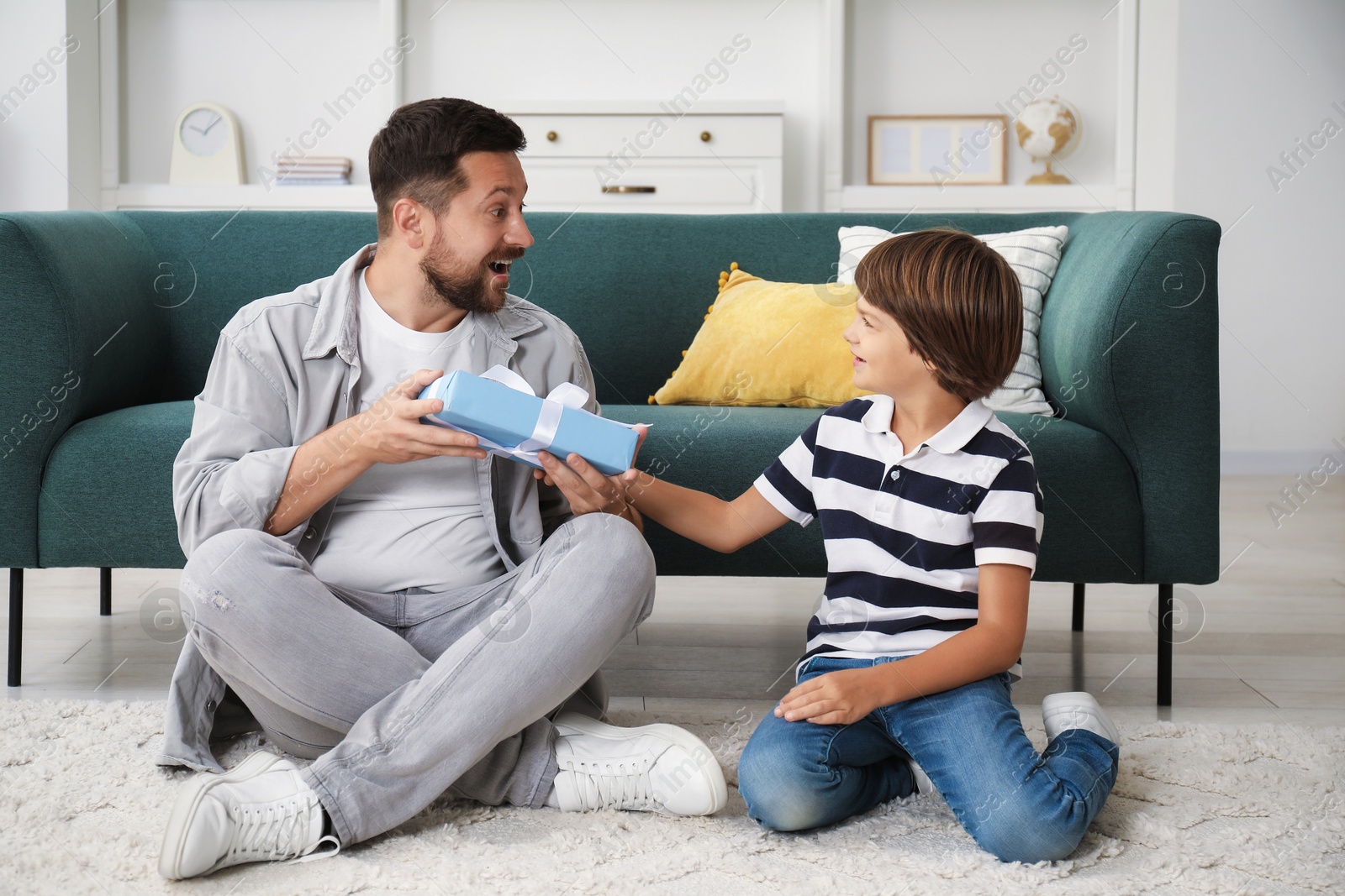 Photo of Happy Father's Day. Son giving his dad gift at home