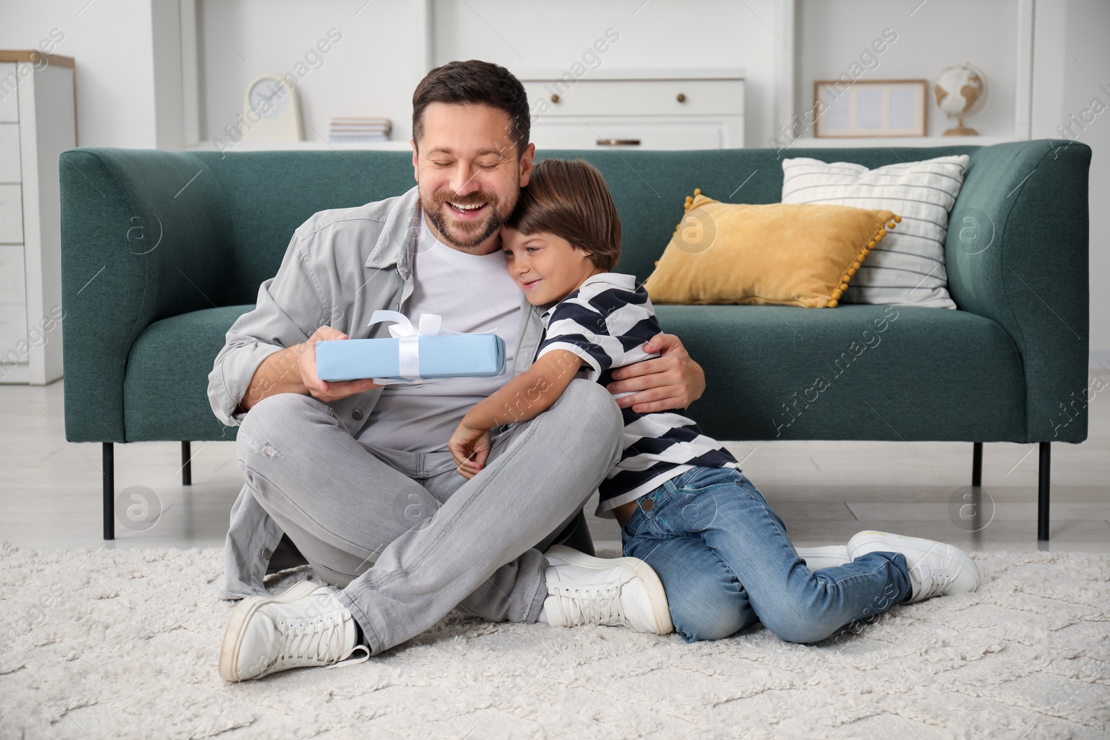 Photo of Happy Father's Day. Son giving his dad gift at home