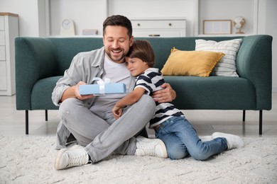 Photo of Happy Father's Day. Son giving his dad gift at home