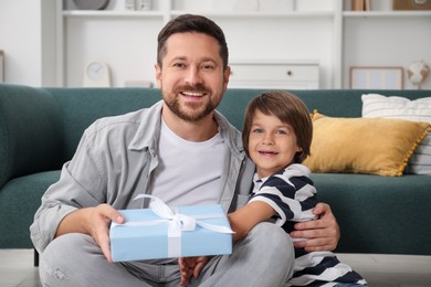 Photo of Happy Father's Day. Son giving his dad gift at home