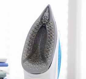 Image of Clothes iron soleplate with burnt residue and scale indoors, closeup